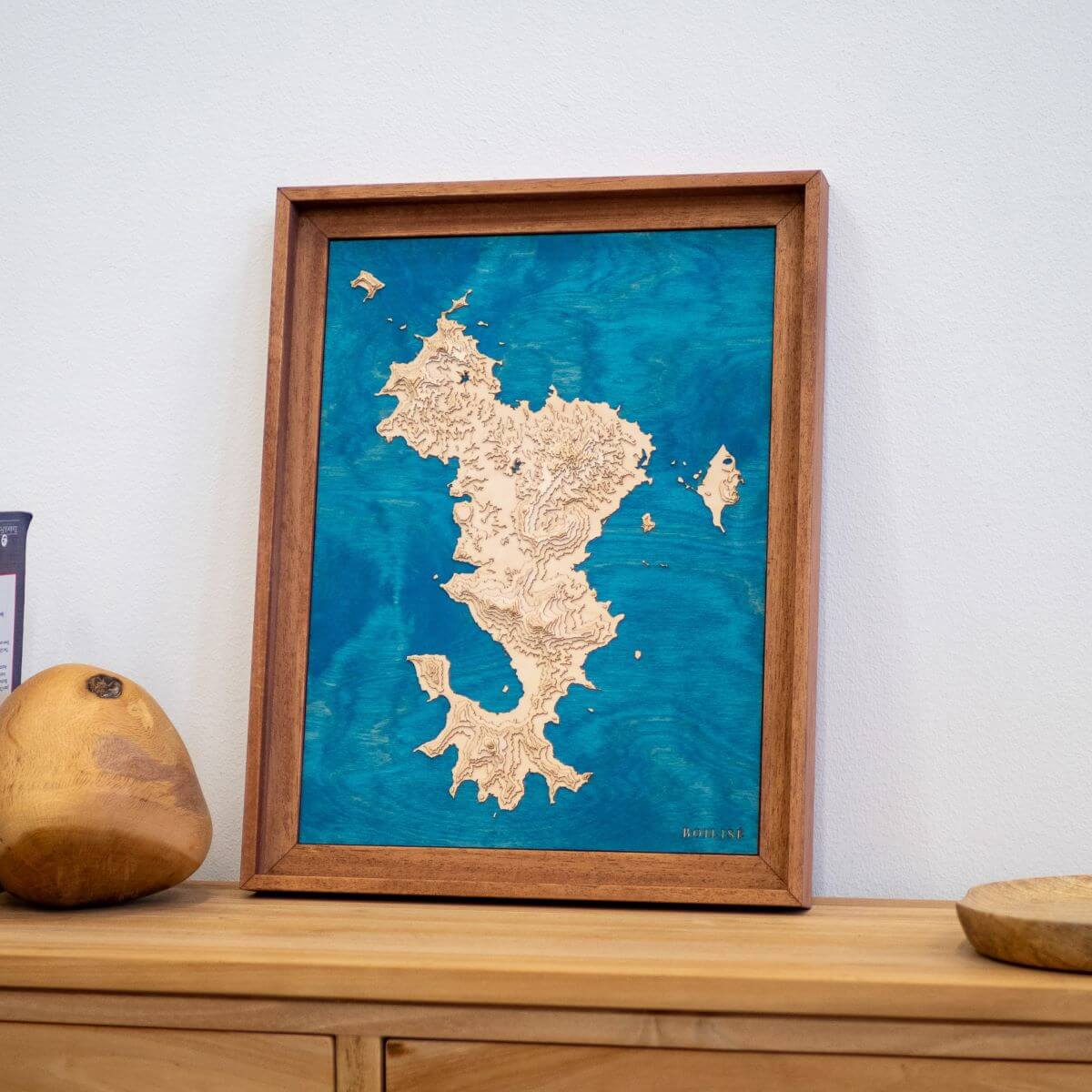 Carte de Mayotte posée sur une commode d'entrée en bois