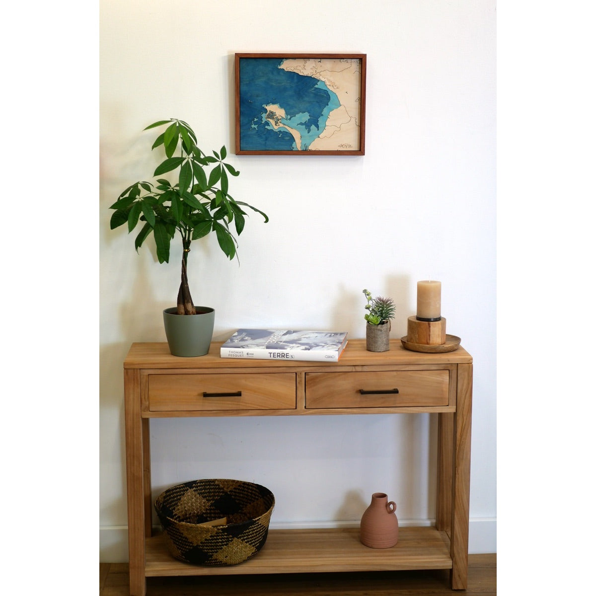 Entrée d'une maison du pays de Retz décorée avec une commode en bois et une carte de la baie de Bourgneuf
